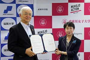 取り交わした協定書を披露する位田隆一学長（左）と藤森陽子学校長（右）