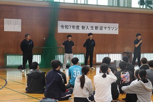 マイクを持って挨拶する学生