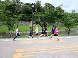 お堀の側を走る学生たち