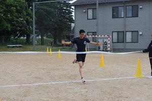 両手を広げてゴールする学生