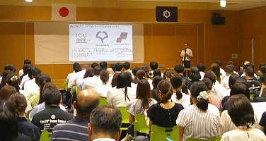 会場いっぱいの聴衆の前で講演する様子