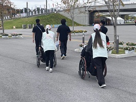 車いすを押す学生たち