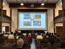 講堂のスクリーンに映して講演している様子