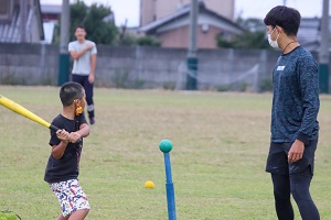 大学生にバッティングの指導をしてもらう子どもたちの様子