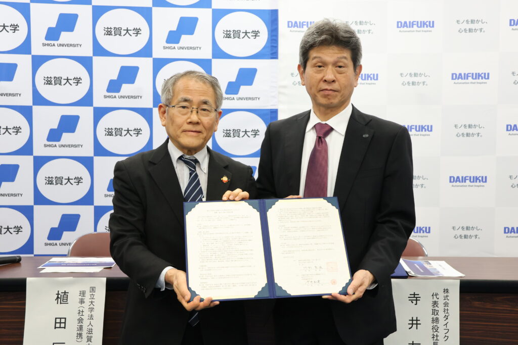 協定書を披露する寺井代表取締役社長(右)と竹村学長(左)