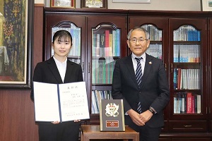 表彰状を手に、学長と記念撮影