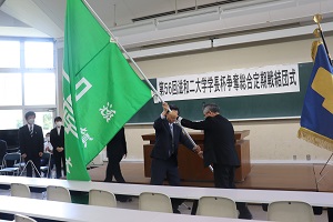 滋賀大学の緑色の団旗を手渡す様子
