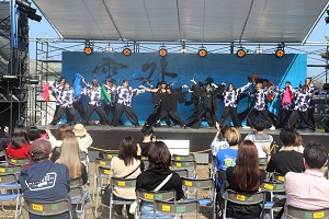 黒い衣装を身に着けステージで踊る学生たち