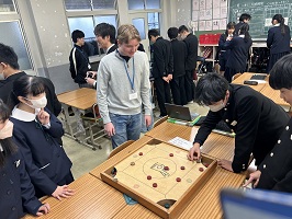 カロムをやって見せる中学生