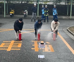 屋外で消火器体験をする学生たち